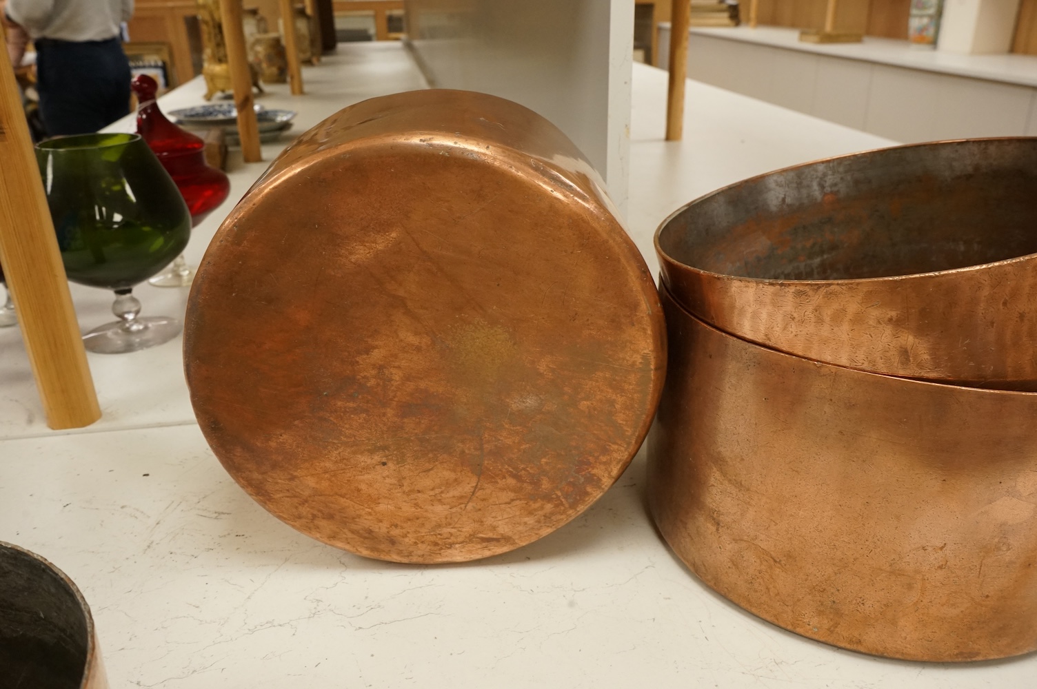 A graduated group of four large copper saucepans